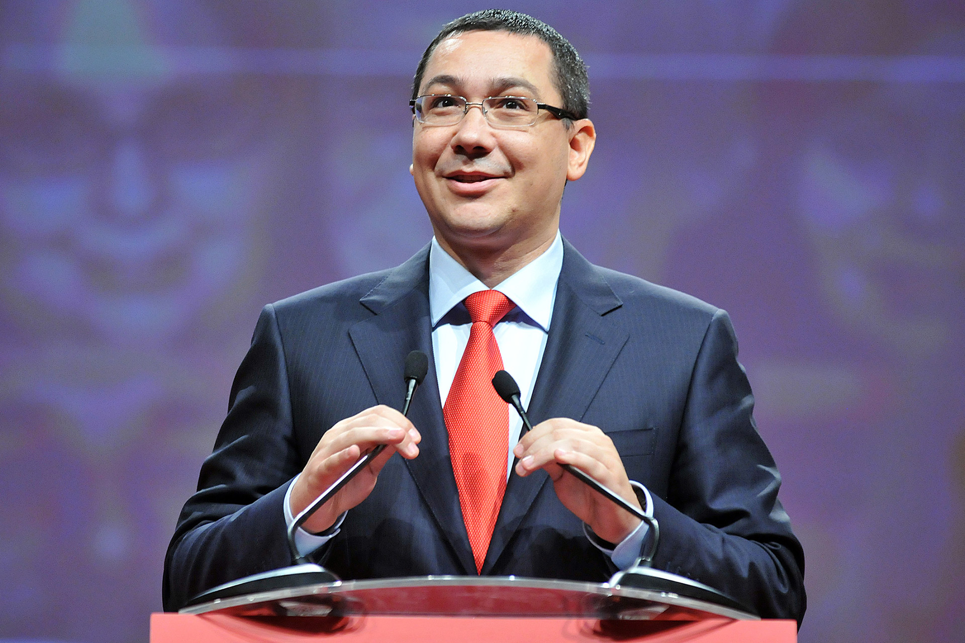 Statsminister Victor Ponta står ved en talerstol og smiler. 