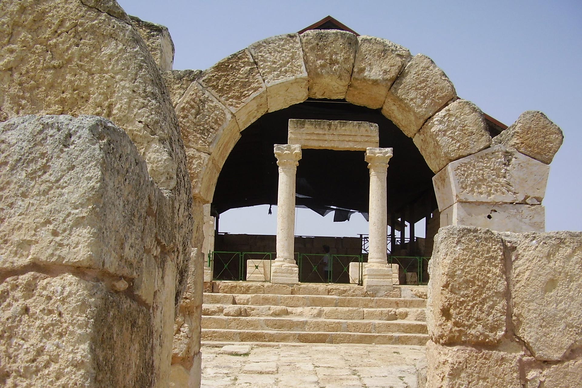Ruiner med romerske buer i forkant av besøkssenteret til Susya-hulene.
